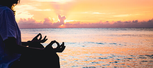 woman in meditation posture by the sea