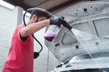 Man washing car engine