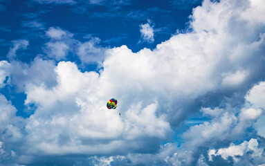 parasailing against blue sky rainbow colors