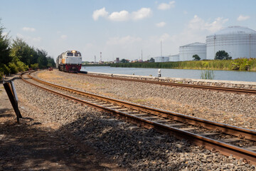 Obraz premium Domestic train pass the rail way when day time with blue sky.