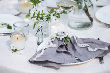 Rustic elegant eco friendly zero waste trendy wedding reception table decor with fresh spring apple cherry flowers in bloom. Beautiful marriage decoration, holiday event outdoors in the family garden