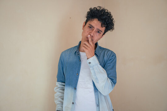 Young curly man wear denim clothes with thanking expression. The photo is suitable to use for man expression advertising and fashion life style.