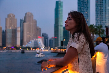 Fototapeta na wymiar Portrait of confident middle-aged adult woman businesswoman at Dubai night city, bored looking away. Pensive jewish woman in summer vacation, resting lady. Leisure activity concept. Copy text space
