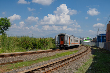 Obraz premium Domestic train pass the rail way when day time with blue sky.