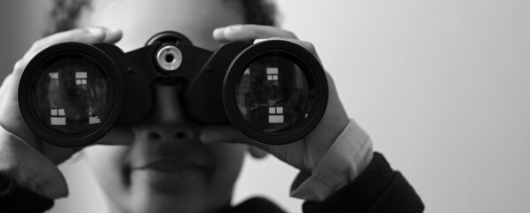 boy looking  through binoculars on grey background stock photo 