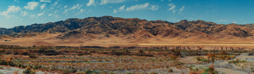 Dried-up river bed on mountains background at summer, Kazakhstan and Kyrgyzstan panoramic view