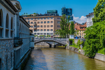 A view along the River Ljubljanica towards the Triple Bridge in Ljubljana, Slovenia in summertime