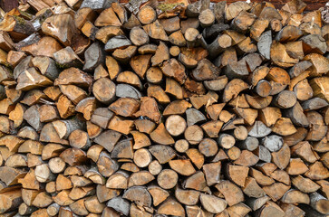 Dry сhopped and stacked firewood close up for home heating consumption in the countryside. Natural texture or background
