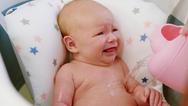 A newborn baby crying inconsolably and refused to have a bath. Unhappy kid takes military procedures for the first time. The concept of children and hygiene