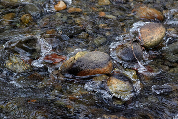 Obraz premium Rocks Surrounded by Ice in a Creek