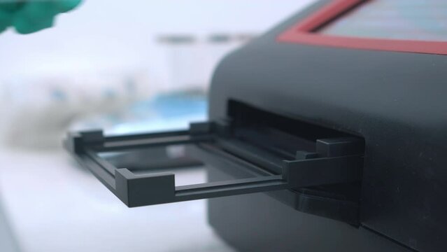 Scientist uses microplate photometers for performing biological and chemical analysis of samples in microtiter plates.