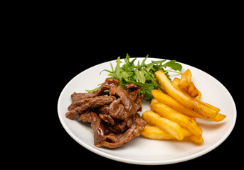 Stir-fried beef served with french fries and arugula leaves on white plate, isolated on black background.