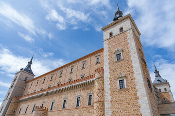 Alcázar de Toledo, una fortificación militar medieval un día soleado con cielo azul y nubes....