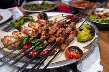 Turkish kebab with lamb skewers and chicken wings, roasted tomatoes and peppers