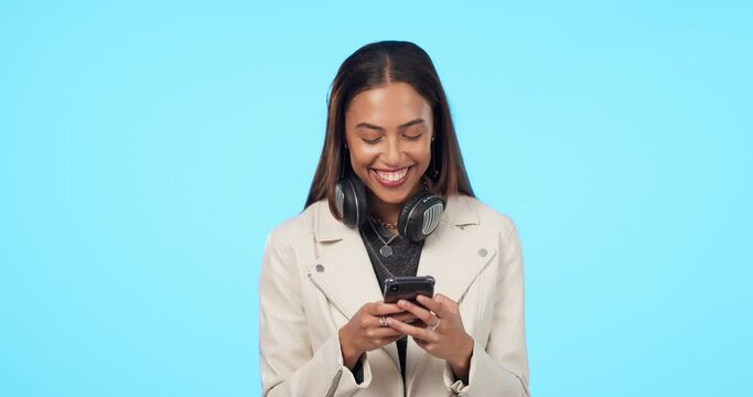 Happy woman, phone and texting in studio, laughing and reading funny email or message on blue background. Smartphone, joke and female laugh at silly comment, post or online comic or streaming meme