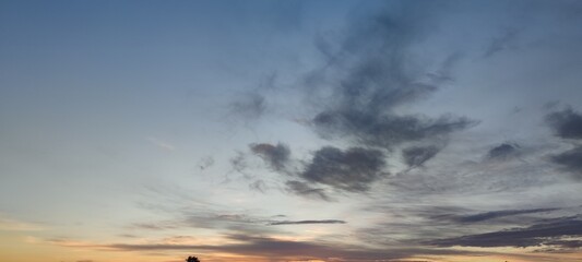 Evening sky with clouds. The sun almost went below the horizon. Dark clouds hang in the sky. They...