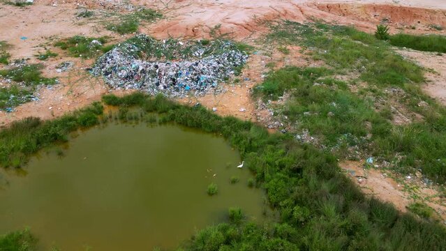 Aerial view rubbish landfill site near pond in Malaysia