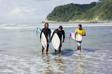 Portrait of latin surfers men with surfboard on the beach in Acapulco Mexico. Hispanic people surfing in summer sport activity