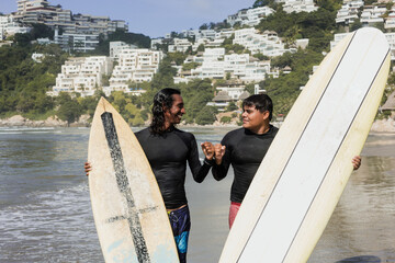 Portrait of latin surfers men with surfboard on the beach in Acapulco Mexico. Hispanic people...