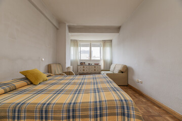 Room with a double bed with a striped bedspread