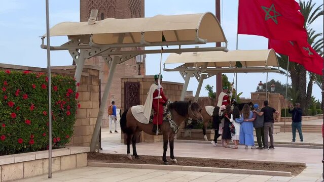 Tourists taking pictures with the royal guards on their horses just outside the Hassan tower temple in Rabat, Morocco