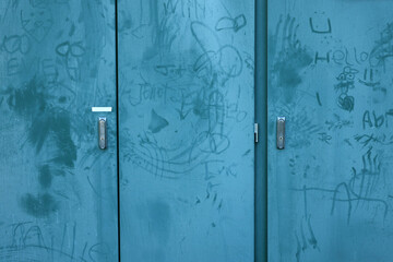 Random graffiti marks on a teal blue public power station cupboard. Poorly hand drawn cock and ball or dick pics with names and illustrations. Vandalism & petty youth crime on public property concept - obrazy, fototapety, plakaty