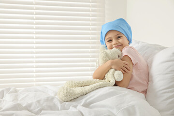 Childhood cancer. Girl hugging toy bunny in hospital