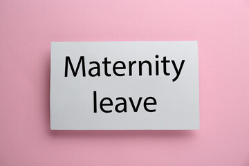 Note with text Maternity Leave on pink background, top view