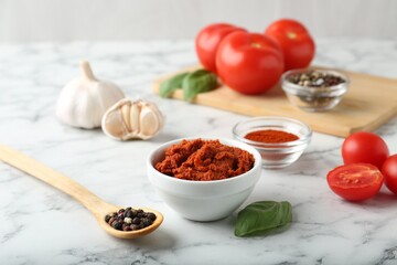 Red curry paste and ingredients on white marble table