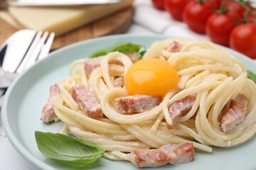Delicious pasta Carbonara with egg yolk on table, closeup