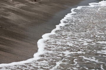 Wave on the black sand beach
