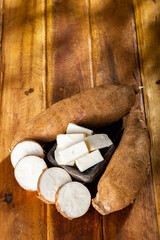 Fototapeta na wymiar pile of cassava, cassava and cassava flour on a background of rustic wood (Manihot esculenta)