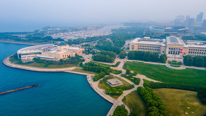 Obraz premium Chicago, IL USA June 29th 2023: aerial drone view of Chicago field museum during when the air is filled with Toxic smog from the Canada wild fires. the sky is filled with grey smoke