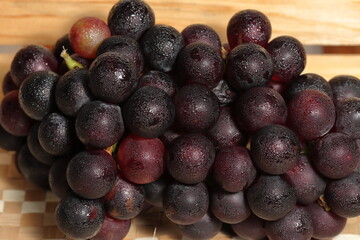 Red grapes on wooden background. Bad cholesterol prevention healthy fruits. Iron fruits