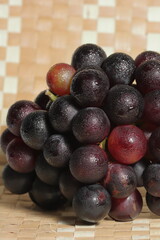 Ripe grapes for sale in the outdoor farm market. Red grapes on wooden background