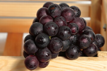 Ripe grapes for sale in the outdoor farm market. Red grapes on wooden background