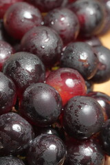 Red grapes on wooden background. Bad cholesterol prevention healthy fruits. Iron fruits