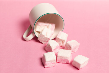 Mug and marshmallows on pink background