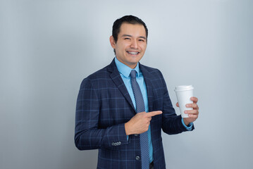 dark skinned mexican young man smiles while pointing his finger at a cup of coffee ready for business work marketing