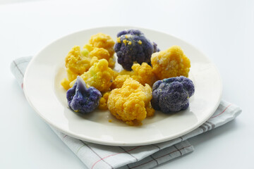 yellow and purple color broccoli on a plate 