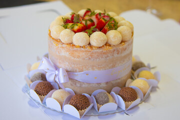 Birthday strawberry cake decorated with various sweets. Selective focus.