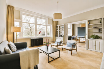 a living room with couches, chairs and a television set in the center of the room is very light wood flooring
