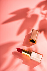 Red lipstick beauty product on a pink background