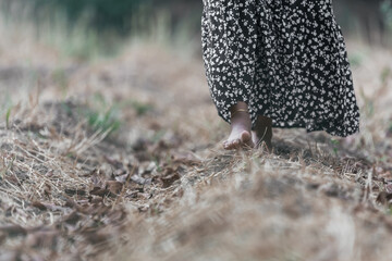 Bare feet of woman stepping on the earth. Nature connection.
