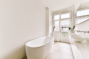 Fototapeta na wymiar a white bathroom with two sinks and a large bathtub in the center of the photo is an open window