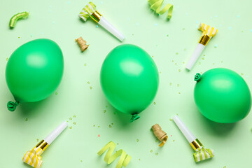 Balloons and whistles for birthday party on pale green background