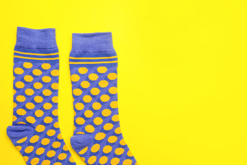 Pair of stylish socks on yellow background, closeup