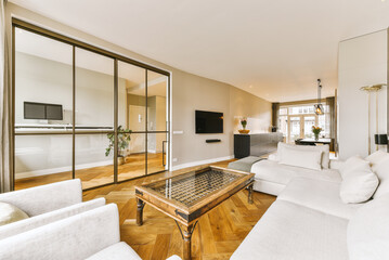 a living room with white couches and large mirrors hanging on the wall behind them to make it look as if they're