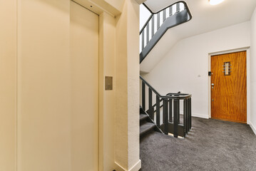 a room with a staircase and an open door that leads to the second floor, which is also in use