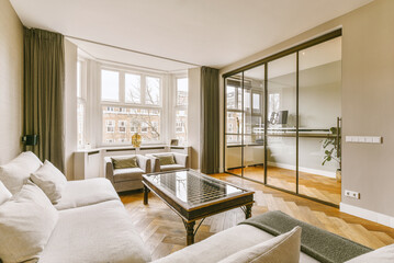 a living room with couches, chairs and a coffee table in front of a large mirror on the wall